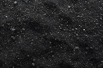 Close-up texture of black sand, showcasing a unique, granular surface