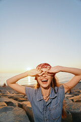 Lifestyle woman wearing modern boho-western denim street style laughing joyfully at sunset by the...