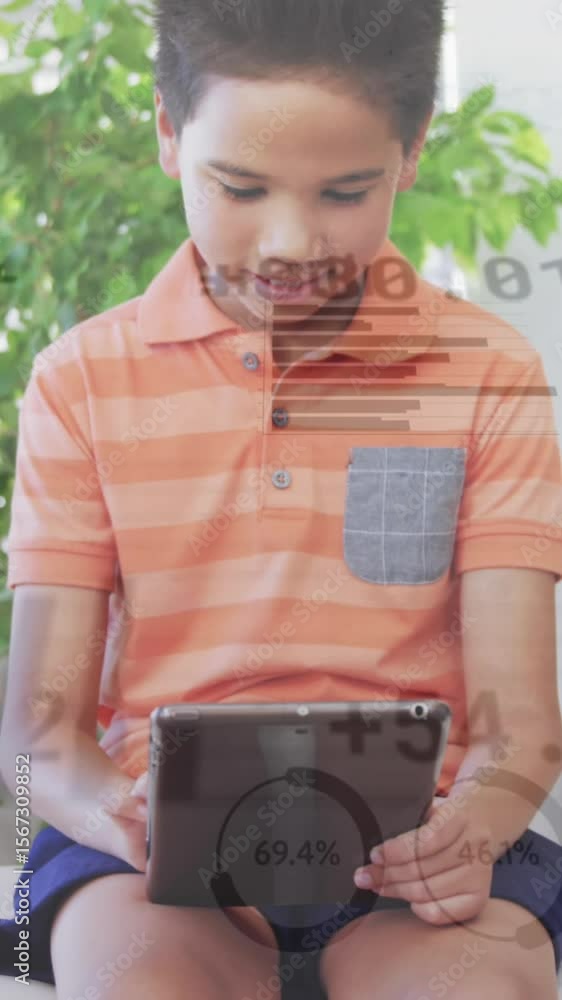 Poster animation of graphs and currency signs over boy using digital tablet while sitting on sofa