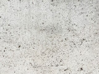 Concrete Texture: A detailed close-up shot revealing the raw, textured surface of light gray concrete, speckled with tiny aggregates.  Ideal for backgrounds and design projects. 