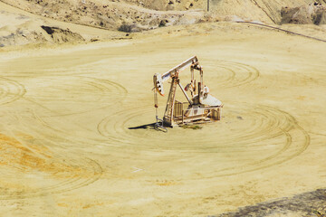 A large oil rig is sitting in the middle of a desert