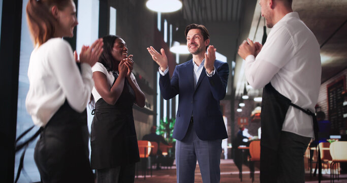 Excited Restaurant Manager Celebrating Success With Waiters