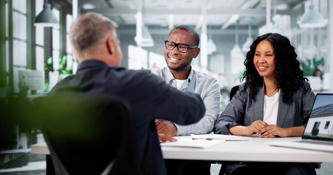 Young Couple Meets Realtor In Office