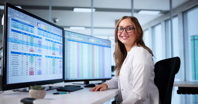 Doctor Reviews Medical Billing And Coding Spreadsheet On Computer Monitor - Powered by Adobe