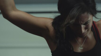 Dedicated woman lifts weights at gym focusing on strength training routine