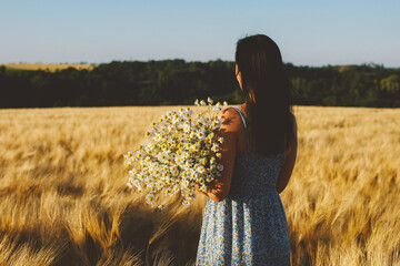 Woman in Wheat Field Holding Chamomile Bouquet