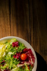 Salad in bowl on wooden table