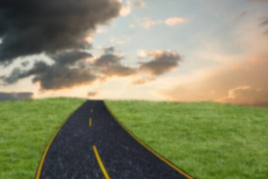 Fototapeta Road amidst grassy field against cloudy sky