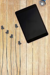 Tablet and plugs on wooden background