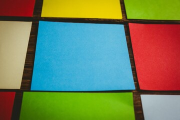 Colorful papers arranged in a row on wooden flooring