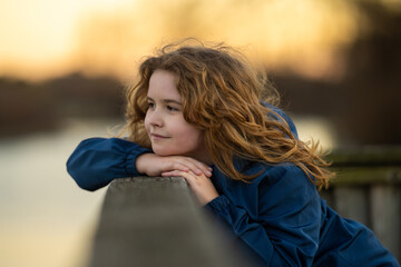 Childhood freedom. Kids portrait. Kid daydreaming in thoughts. Pretty blonde child with a dreamy...