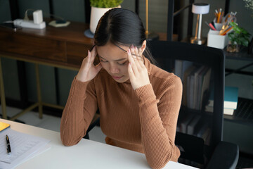 Stressed Asian Woman Holding Head While Working