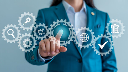 A person in a teal suit interacts with a glowing holographic gear interface displaying business icons on a soft blue-gray background