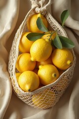 Fresh lemons collected in a netted bag on soft fabric surface