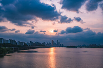 A view of the sunset city of Yeouido in the financial district taken on the Dongjak Bridge on the Han River in summer evening
