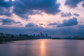 A view of the sunset city of Yeouido in the financial district taken on the Dongjak Bridge on the Han River in summer evening
