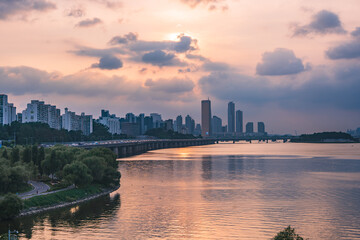 A view of the sunset city of Yeouido in the financial district taken on the Dongjak Bridge on the Han River in summer evening
