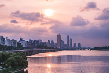 A view of the sunset city of Yeouido in the financial district taken on the Dongjak Bridge on the Han River in summer evening
