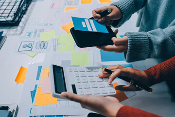 UX UI designer testing prototype on a phone, discussing and brainstorming on wireframes for a...