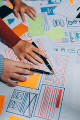 UX UI designer testing prototype on a phone, discussing and brainstorming on wireframes for a...