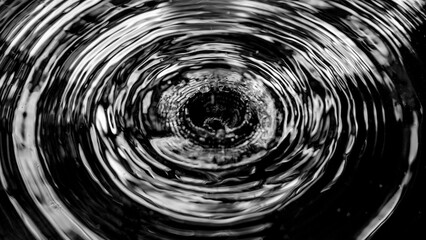 Water ripples or water drops splashing on black background.