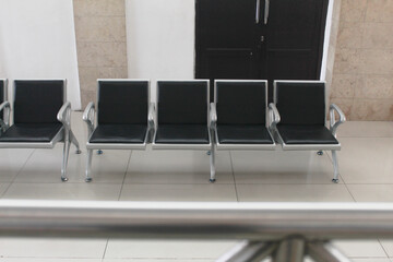 Kertosono, Indonesia July 06, 2025: Empty metal chairs with black cushions in a waiting area.