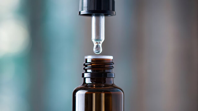 Dropper bottle is shown with drop of liquid about to fall, emphasizing importance of preventive health measures like cancer screening