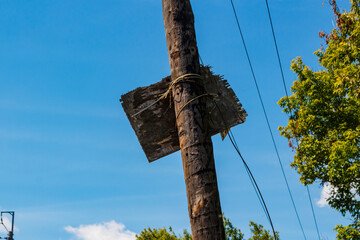 Old peeling signboard fixed to a wooden pole