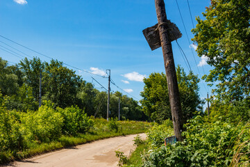 Country road going right with a leaning wooden utility pole
