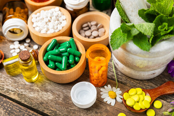 Alternative medicine herbal capsule organic drug on wooden background.Assortment of herbal and...