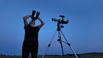 Amateur astronomer using telescope and binoculars for watching stars, Moon, planets and other...