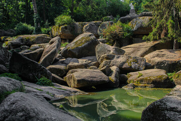 Serene Green Pond Amidst Ancient Boulders