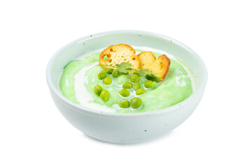 Green pea soup isolated on white background. Fresh pea soup bowl. Delicious healthy cream soup in a bowl with green peas and croutons. Healthy vegan puree.