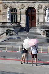 Couple with a sun umbrella visiting Bilbao in a summer day