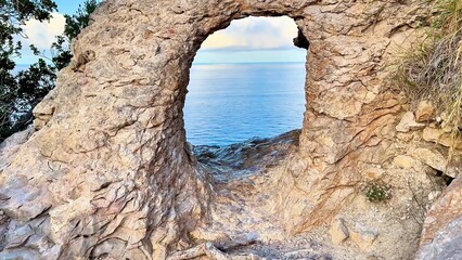 A stunning rock arch beautifully framing a serene ocean landscape, captivating during a breathtaking sunset
