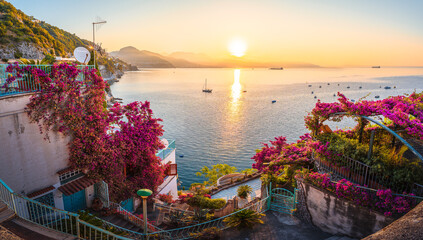 Fototapeta na wymiar Romantic sunrise on the Amalfi Coast with blooming bougainvillea and sea views.