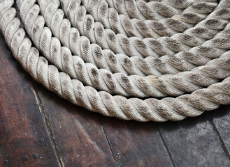 A sailor ropes is laying spread out on a wooden floor