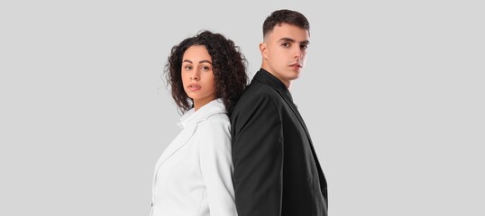 Young stylish couple on light background. Yin Yang concept