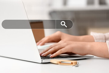 Woman with USB flash drive and modern laptop at light table, closeup