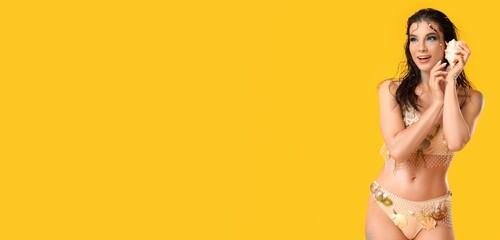 Beautiful young woman dressed as siren on yellow background with space for text