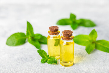Essential oil mint on a wooden background. Peppermint essential oil with fresh mint leaves. A bottle of aromatherapy oil. Mint extract. The concept of natural cosmetics, spa care. copy space