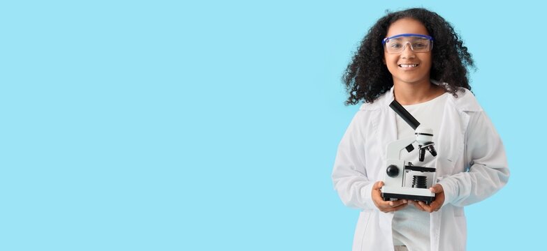African-American schoolgirl with microscope on blue background with space for text