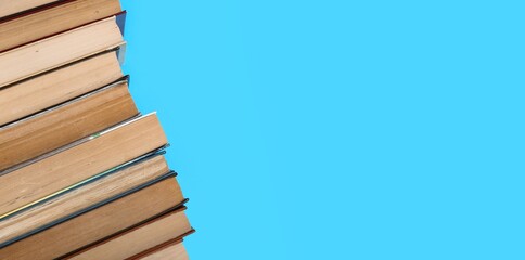 Stack of books on blue background with space for text, closeup