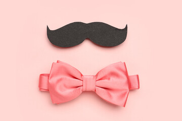 Paper mustache and stylish bow tie on pink background