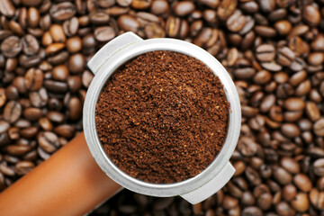 Portafilter with coffee powder and beans, closeup