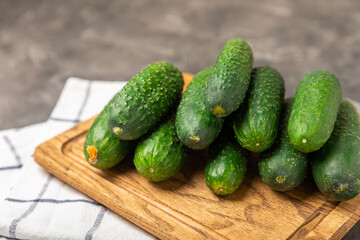 Cucumber on wooden background. Slice of cucumber on background. Fresh organic green cucumbers gherkin. Vegan. Salad ingredient. Farm vegetables. Cut vegetables with knife. Space for text. Copy space