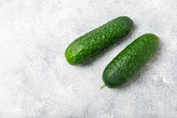 Cucumber on wooden background. Slice of cucumber on background. Fresh organic green cucumbers gherkin. Vegan. Salad ingredient. Farm vegetables. Cut vegetables with knife. Space for text. Copy space
