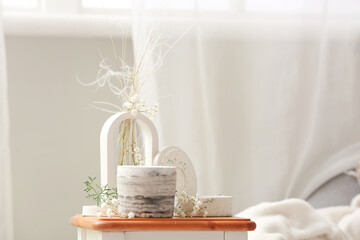 Gypsophila flowers and candles on table in living room