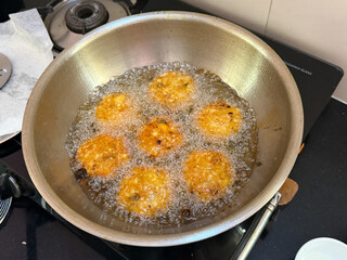A pan of fried food is being cooked on a stove