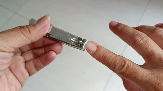 Asian Man's hands with dirty nail using nail clipper for fingernails manicure